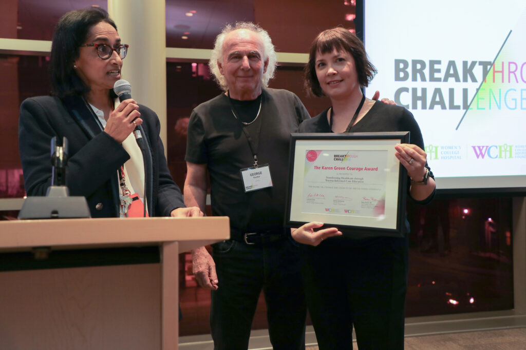 Dr. Dana Ross standing alongside George Fisher and Dr. Rulan Parekh while holding up "Karen Green Courage Award" certificate.